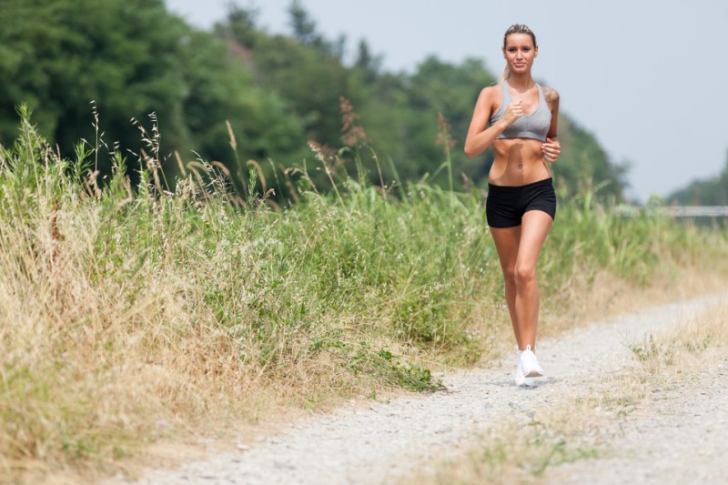 Beautiful blonde woman running along the riverside